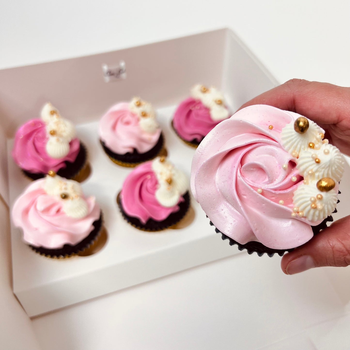 Delicious light pink and darker pink buttercream chocolate cupcakes with white and gold detail. Made by Cute Cakes and Co. Brisbane cake shop near you. Same day orders. We deliver to your door