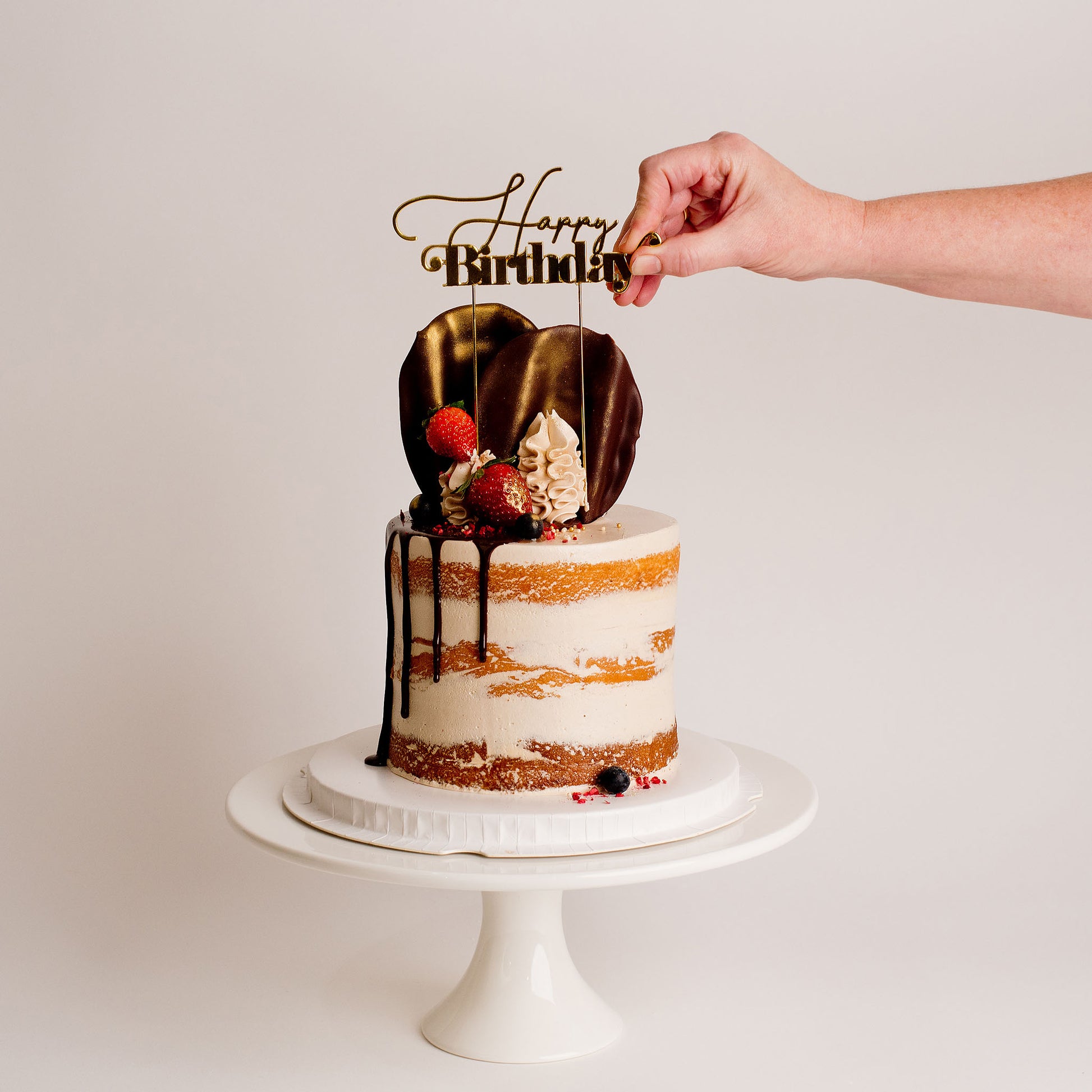 Semi-naked caramel layered cake looks and tastes gorgeous with its buttercream icing, seasonal fruit, chocolate sail and delicious dripping gold. Cute Cakes & Co, Cute Cakes and Co