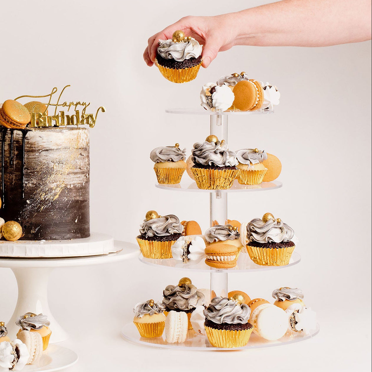 Cupcakes on a stand, with a hand hold one of them. Black, white and gold theme
Looks fabulous, Made with love by Cute Cakes and Co. the 5 star review cake shop, in Brisbane.