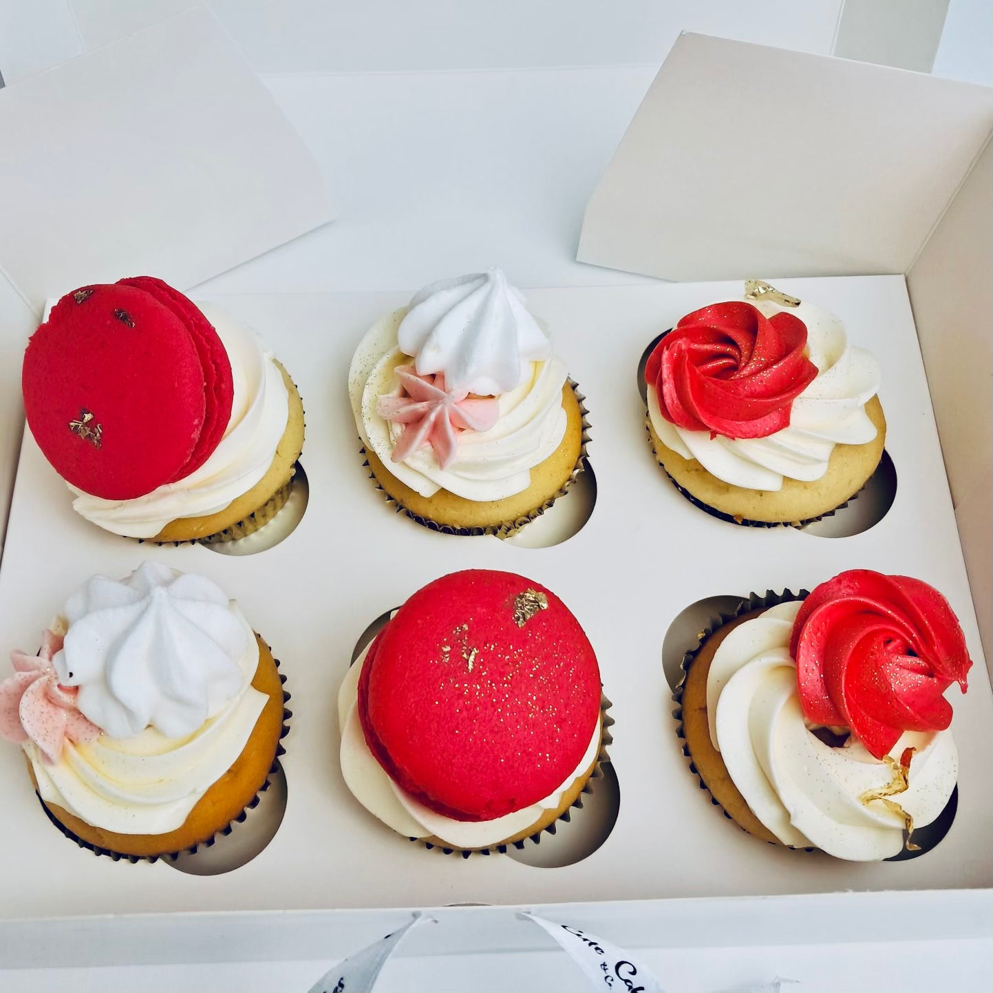 A box of beautifully decorated cupcakes with gold papers, Italian buttercream topped with macarons, meringues and edible glitter.
Made by Cute Cakes and Co . 5 star cake shop in Brisbane. Same day delivery service