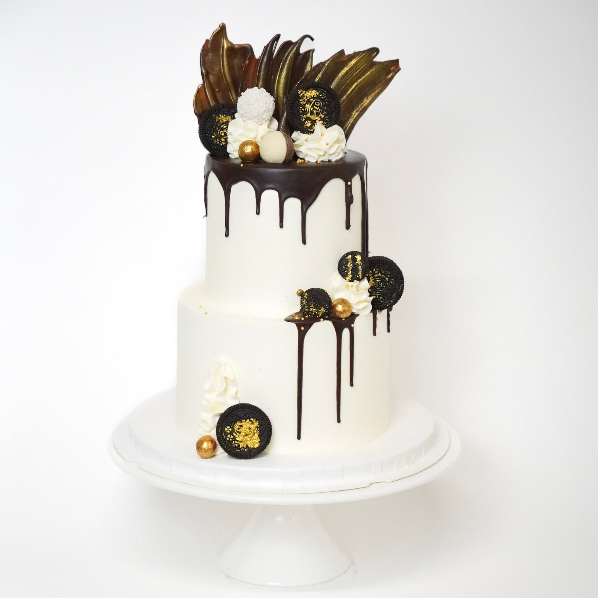 The Jo cake is generously covered with  luxurious buttercream and dripping of silky chocolate ganache drips down the sides, adding a touch of elegance and indulgence. Three golden chocolate sails stand tall on top of the cake, with Oreo Cookies, Raffaello chocolates, and Maltesers. Made by Cute Cakes & Co. 5 star cake shop in Brisbane 
Birthdays, anniversary weddings, gender reveal. 
Same day ordering available