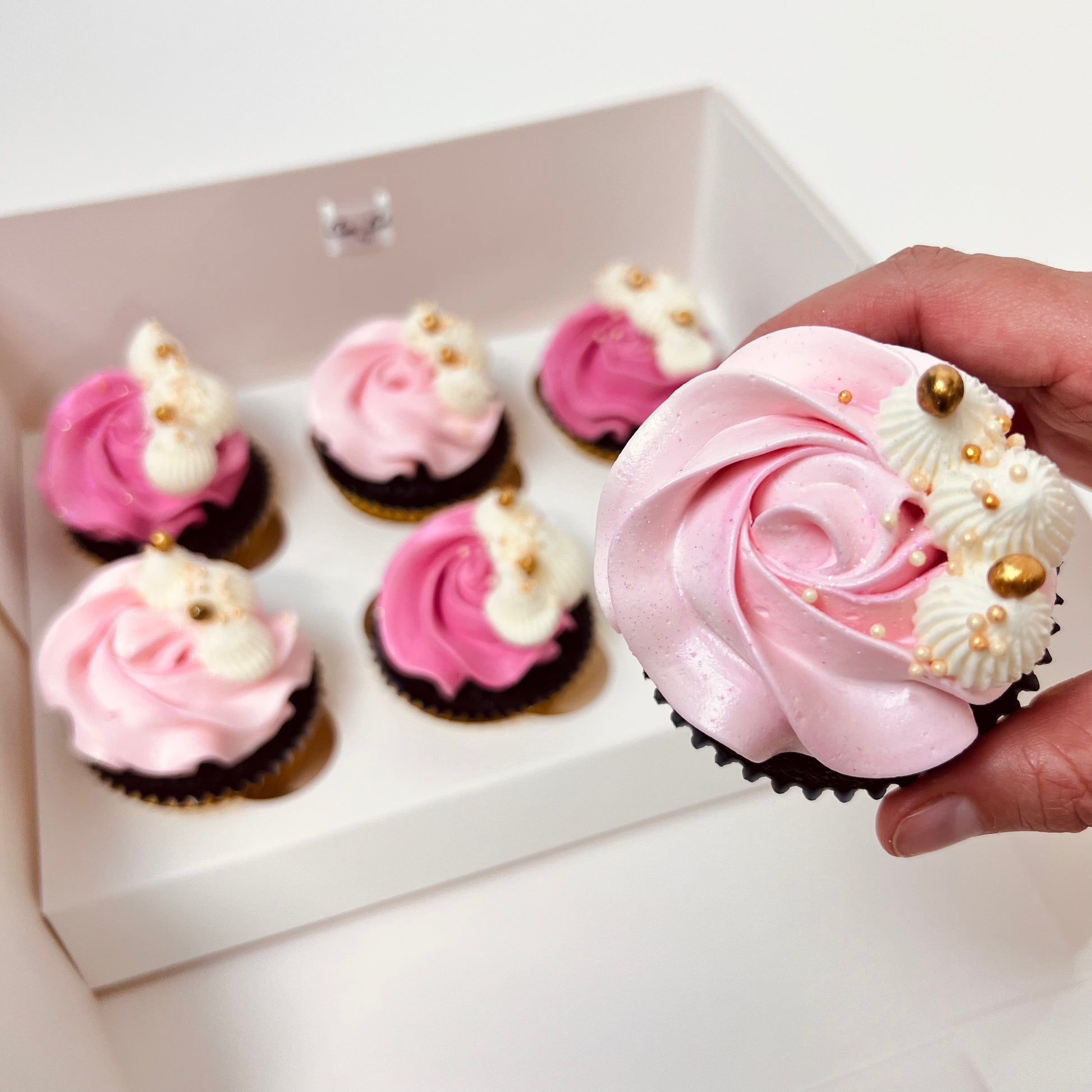Delicious light pink and darker pink buttercream chocolate cupcakes with white and gold detail. Made by Cute Cakes and Co. Brisbane cake shop near you. Same day orders. We deliver to your door 