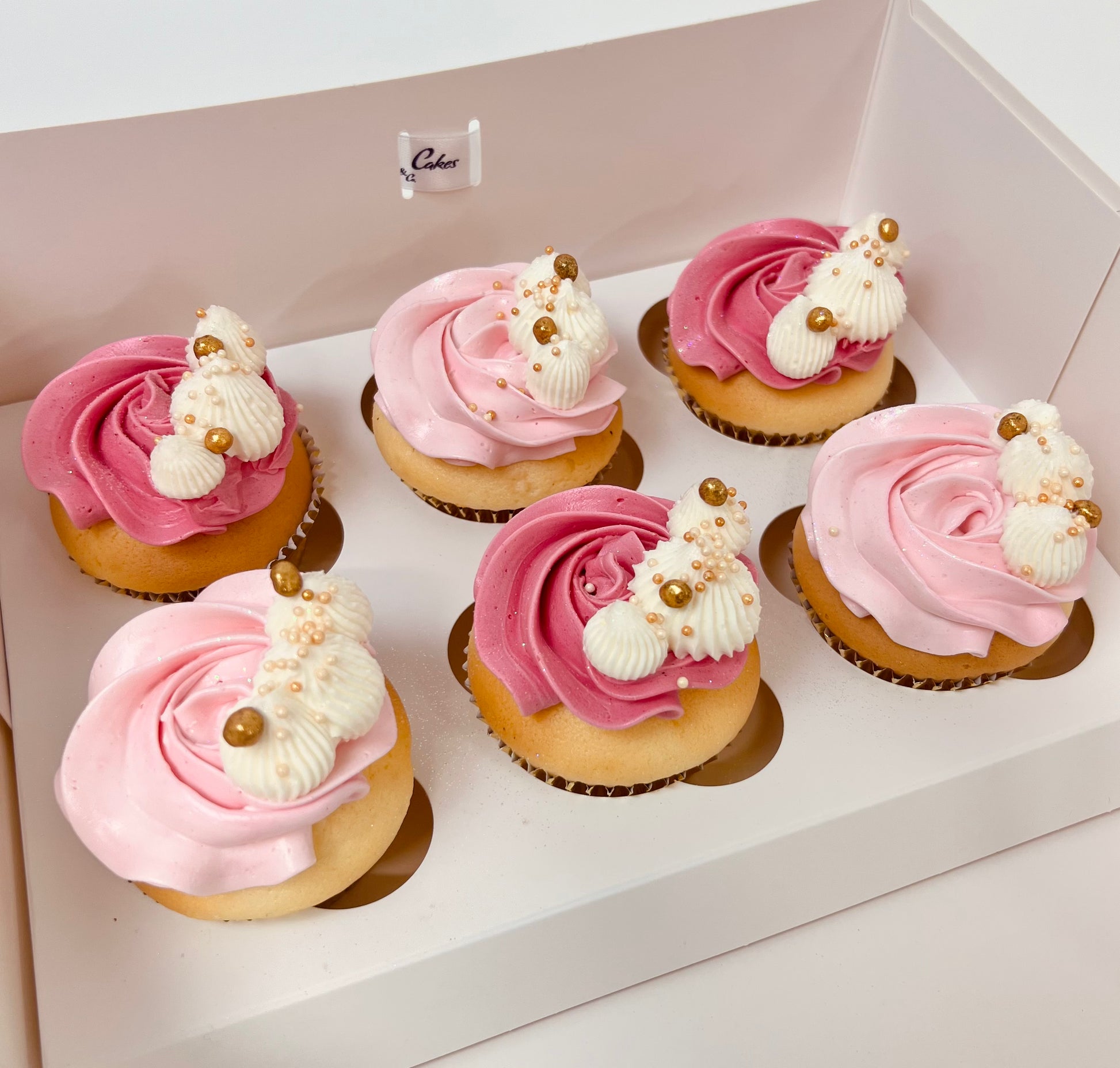Delicious light pink and darker pink buttercream vanilla cupcakes with white and gold detail. Made by Cute Cakes and Co. Brisbane cake shop near you. Same day orders. Deliver to your door 