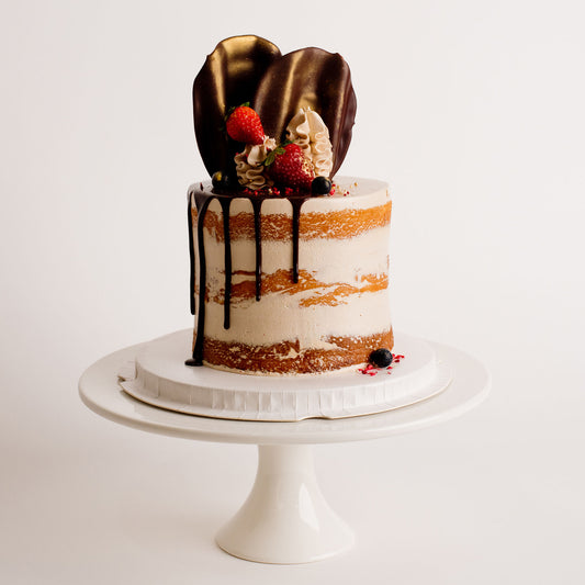 Semi-naked caramel layered cake looks and tastes gorgeous with its buttercream icing, seasonal fruit, chocolate sail and delicious dripping gold. Cute Cakes & Co, Cute Cakes and Co