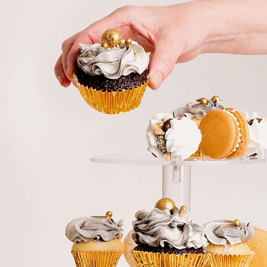 chocolate cupcakes with a mix of black and white buttercream. Decorated with gold ball and Gold papers. 