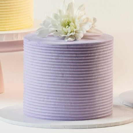 Light purple cake, decorated with ribbed buttercream feature on the sides and white fresh flowers on the top. Made with love by Brisbane’s favourite, 5 star cake shop, Cute Cakes & Co 