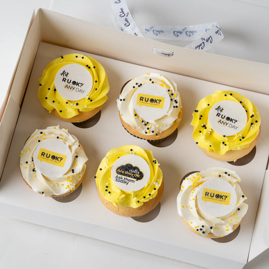 6 RU OK Day Cupcake with yellow & White buttercream topped with an edible disk that has 'R U OK?' written on it.