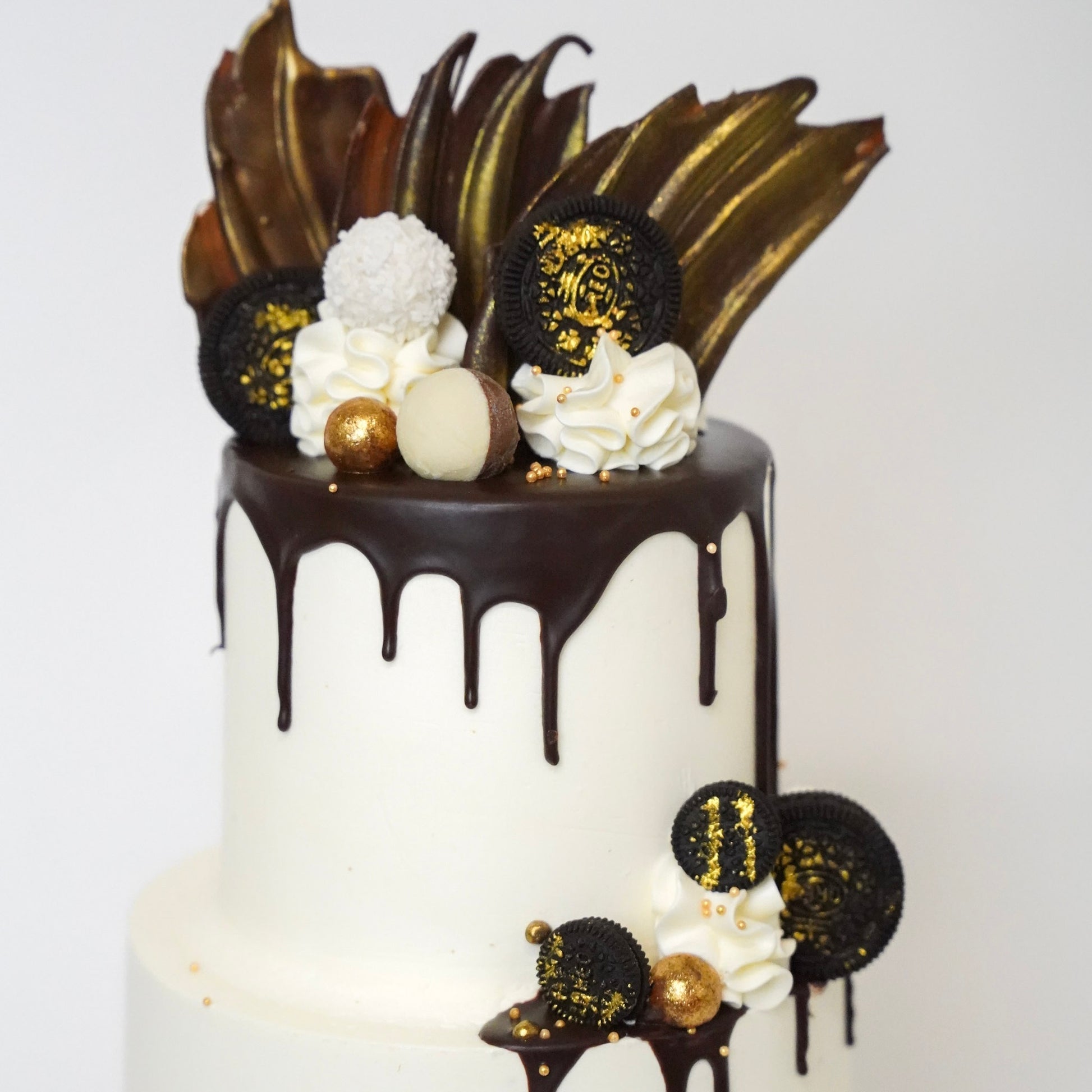  The Jo cake is generously covered with  luxurious buttercream and dripping of silky chocolate ganache drips down the sides, adding a touch of elegance and indulgence. Three golden chocolate sails stand tall on top of the cake, with Oreo Cookies, Raffaello chocolates, and Maltesers. Made by Cute Cakes & Co. 5 star cake shop in Brisbane 
Birthdays, anniversary weddings, gender reveal. 
Same day ordering available 