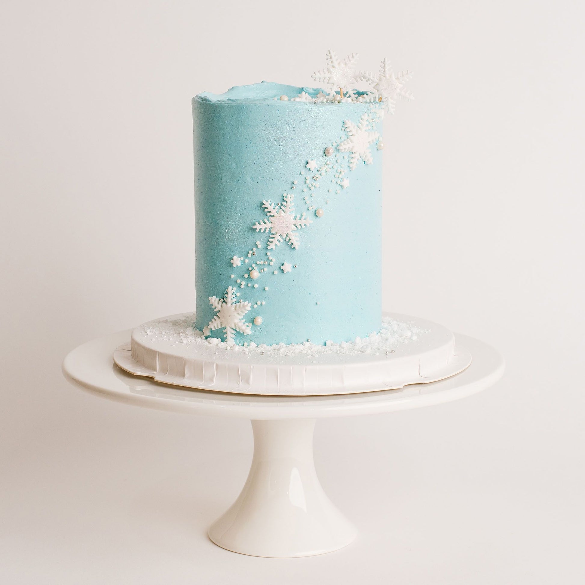 Disney Frozen themed birthday cake iced in light blue buttercream with snowflakes stars and glitter perfect for a little girl's birthday Looks fabulous.   Made with love by the five star cake shop ,Cute Cakes and Co, Brisbane.  Mitchelton , Cake shop near you 