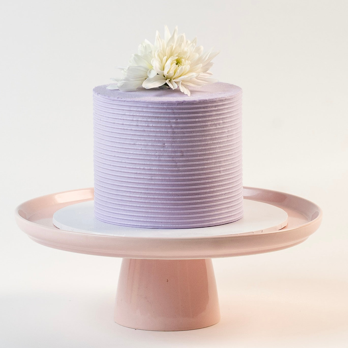 Light purple cake, decorated with ribbed buttercream feature on the sides and white fresh flowers on the top. Made with love by Brisbane’s favourite, 5 star cake shop, Cute Cakes & Co 