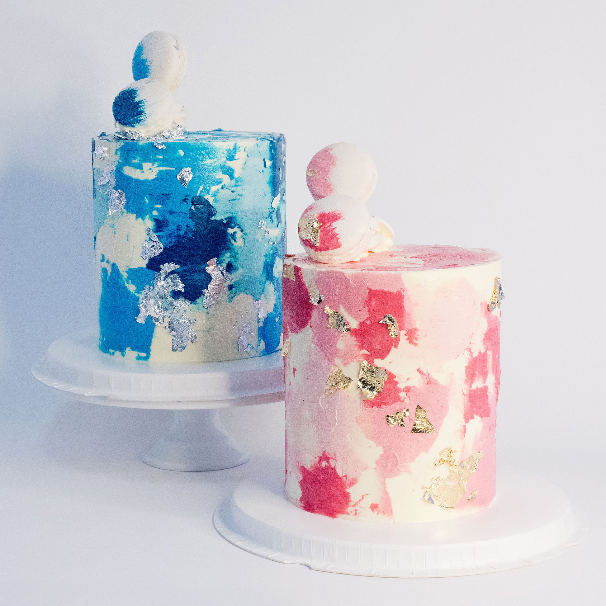 Blue and pink birthday cake with silver leaf, white macarons and soft buttercream texture