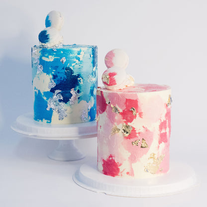 Blue and pink birthday cake with silver leaf, white macarons and soft buttercream texture