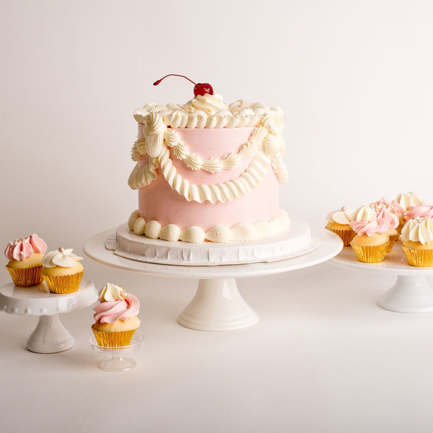Mini vintage birthday cake with pink buttercream piping with lux mini cupcakes 