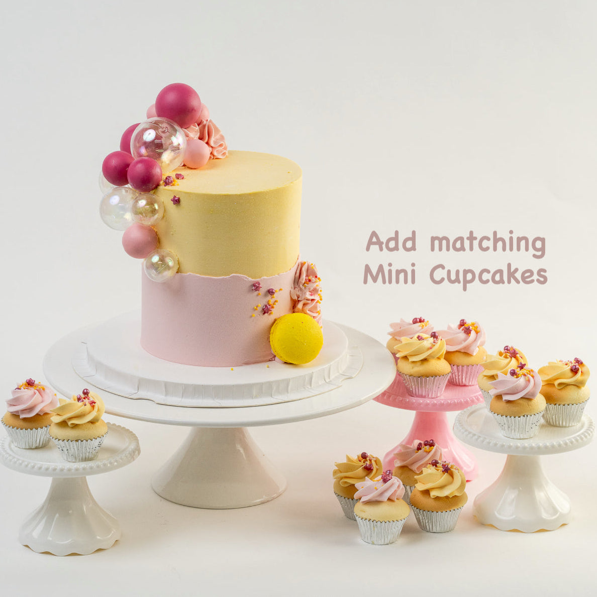 Mini cupcakes and a  pretty pink and yellow cake with a side decoration of shades of pink and clear balls. Wiggle and yellow macaron at the base. glitter perfect for a  girl's birthday Looks fabulous.  Made with love by Cute Cakes & Co, Brisbane Favourite cake shop. 
5 star review cake shop in Brisbane. 