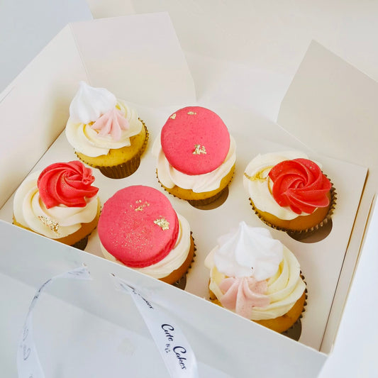 A box of beautifully decorated cupcakes with gold papers, Italian buttercream topped with macarons, meringues and edible glitter.
Made by Cute Cakes and Co . 5 star cake shop in Brisbane. Same day delivery service  
