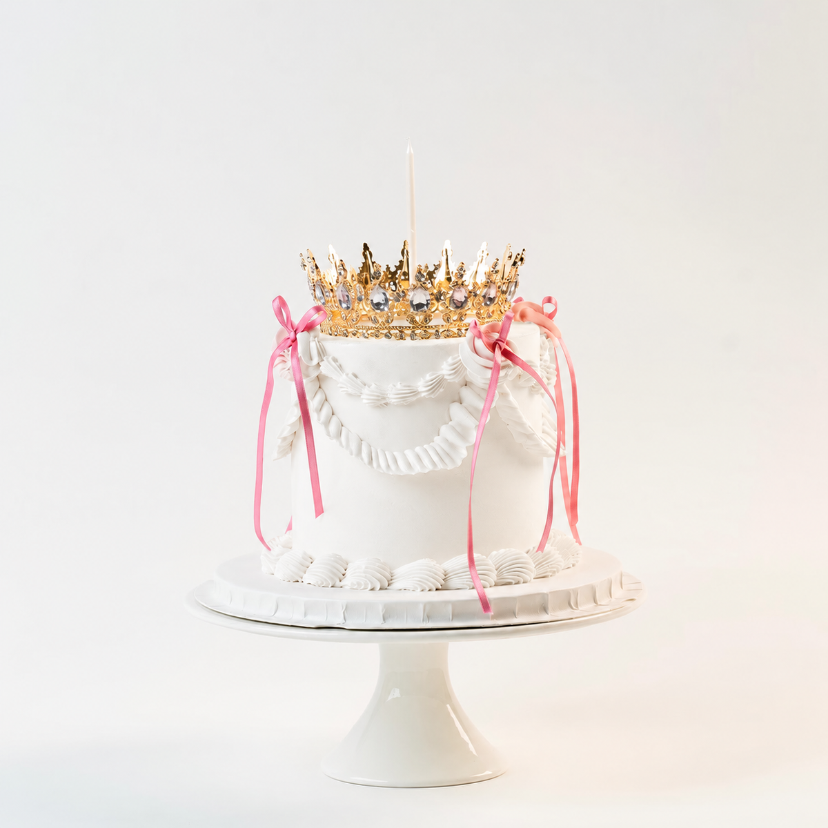 White  Vintage style  cake. Pink ribbon bow with a crown on the top and candle.