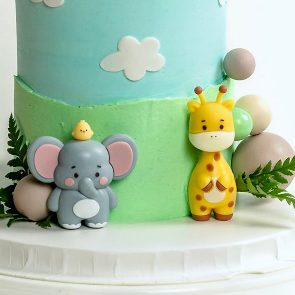 Wild Ones cake with elephant and giraffe figurines for a kids’ birthday