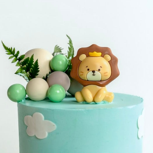 Kids jungle cake with lion topper, decorative greenery and buttercream details