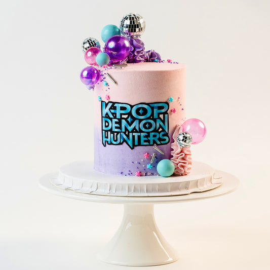 K-pop Demon Hunters birthday cake. 
Pink, blue and purple buttercream and decorations. With disco balls. K-Pop Demon Hunters logo at the front. Made with love by Brisbane’s favourite, 5 star cake shop, Cute Cakes & Co 
