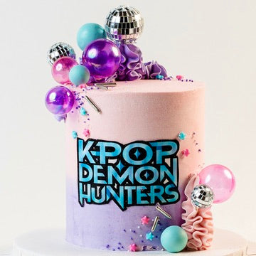 K-pop Demon Hunters birthday cake. 
Pink, Blue and purple buttercream and decorations. With disco balls. K-Pop Demon Hunters logo at the front. Made with love by Brisbane’s favourite, 5 star cake shop, Cute Cakes & Co 