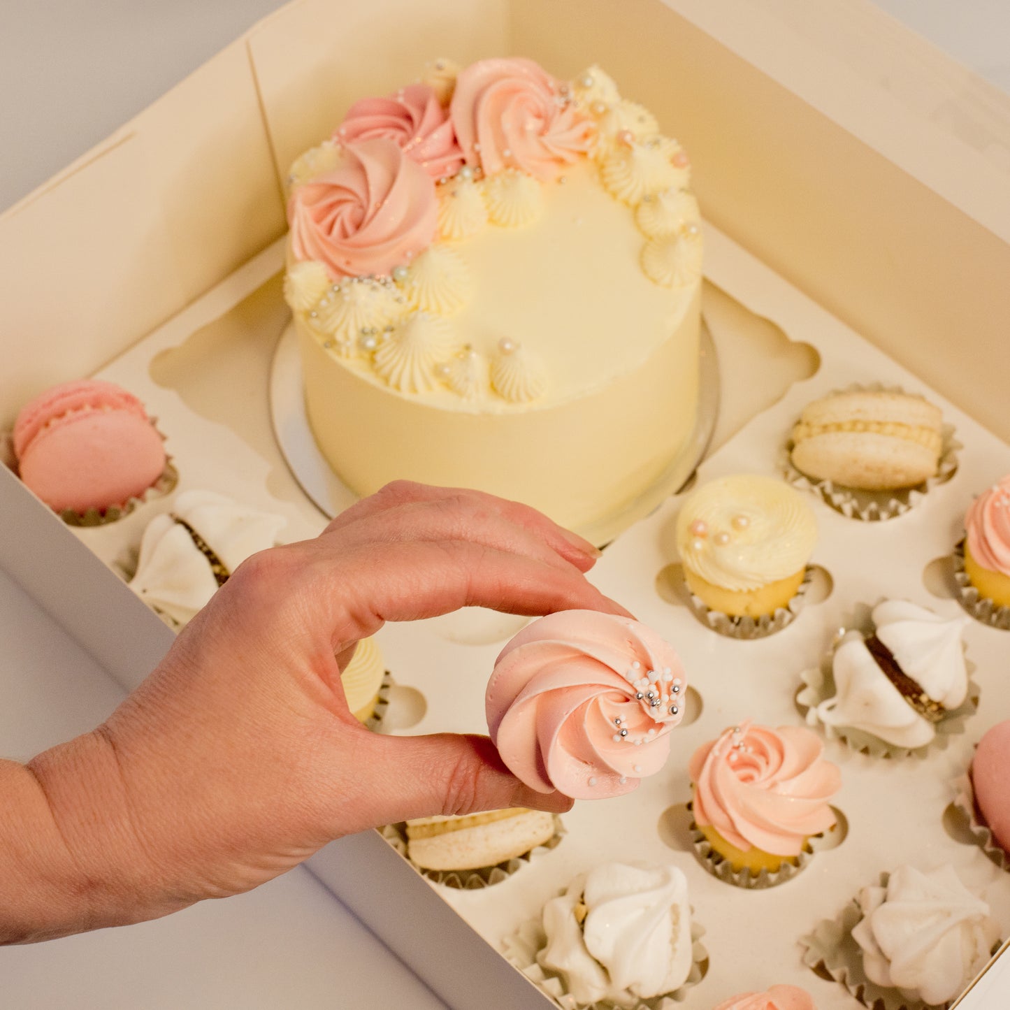 Cute cake and cupcake pack. Pretty pink and white cake decorated with tasty buttercream. Plus mini cupcakes, meringue kisses and macarons. Ideal for work and corporate birthday celebrations. Cute Cakes & Co, Cute Cakes and Co, Brisbane online cake shop, Caxton Street cake shop