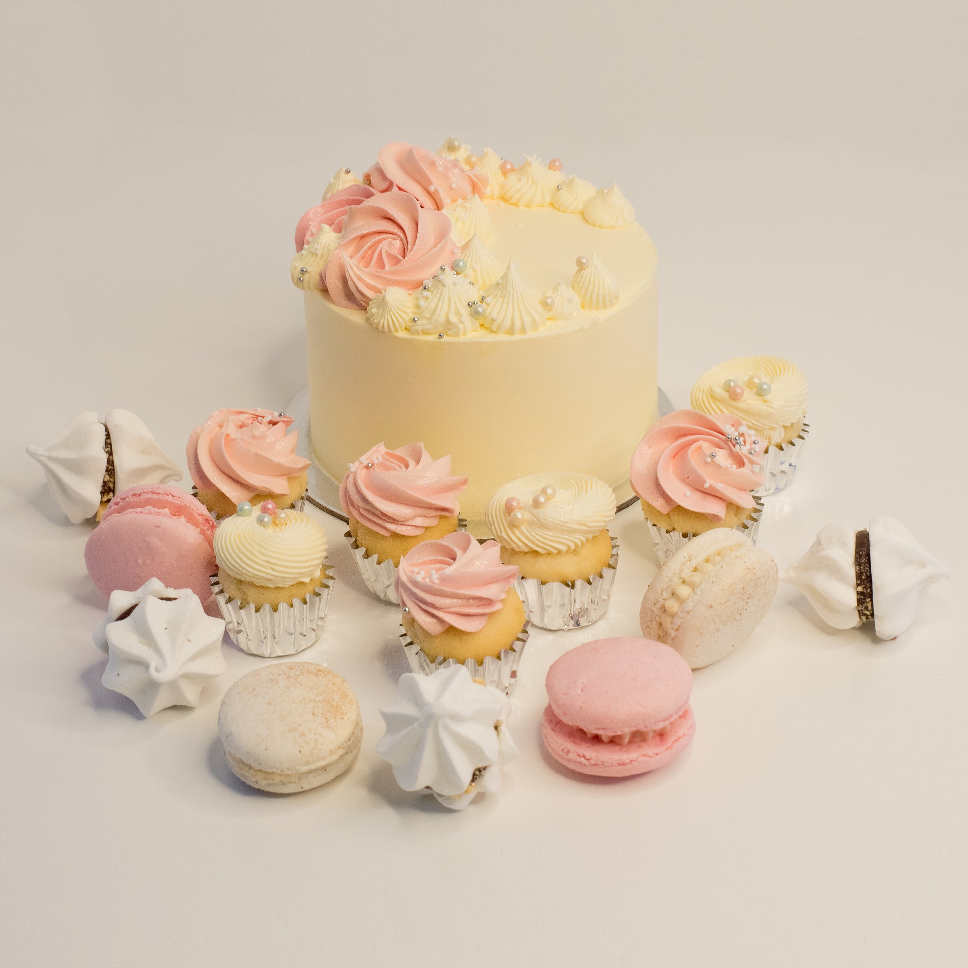 Cute cake and cupcake pack. Pretty pink and white cake decorated with tasty buttercream. Plus mini cupcakes, meringue kisses and macarons. Ideal for work and corporate birthday celebrations. Cute Cakes & Co, Cute Cakes and Co, Brisbane online cake shop, Caxton Street cake shop