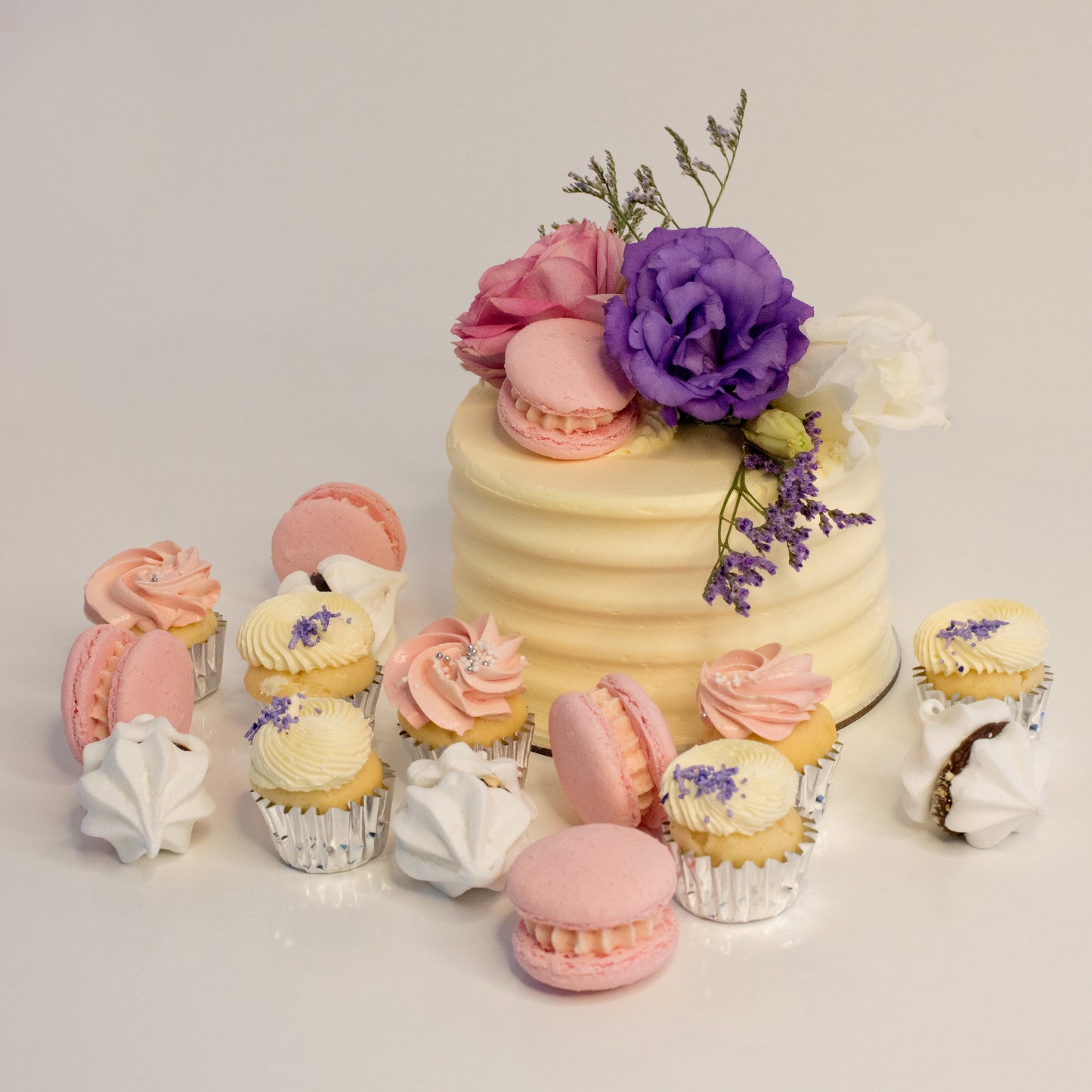 Cute cake and cupcake pack. This cake has a stunning arrangement of fresh flowers and macarons sweeping across the top. Plus mini cupcakes, meringue kisses and macarons. Ideal for work and corporate birthday celebrations. Cute Cakes & Co, Cute Cakes and Co, Brisbane online cake shop, Caxton Street cake shop