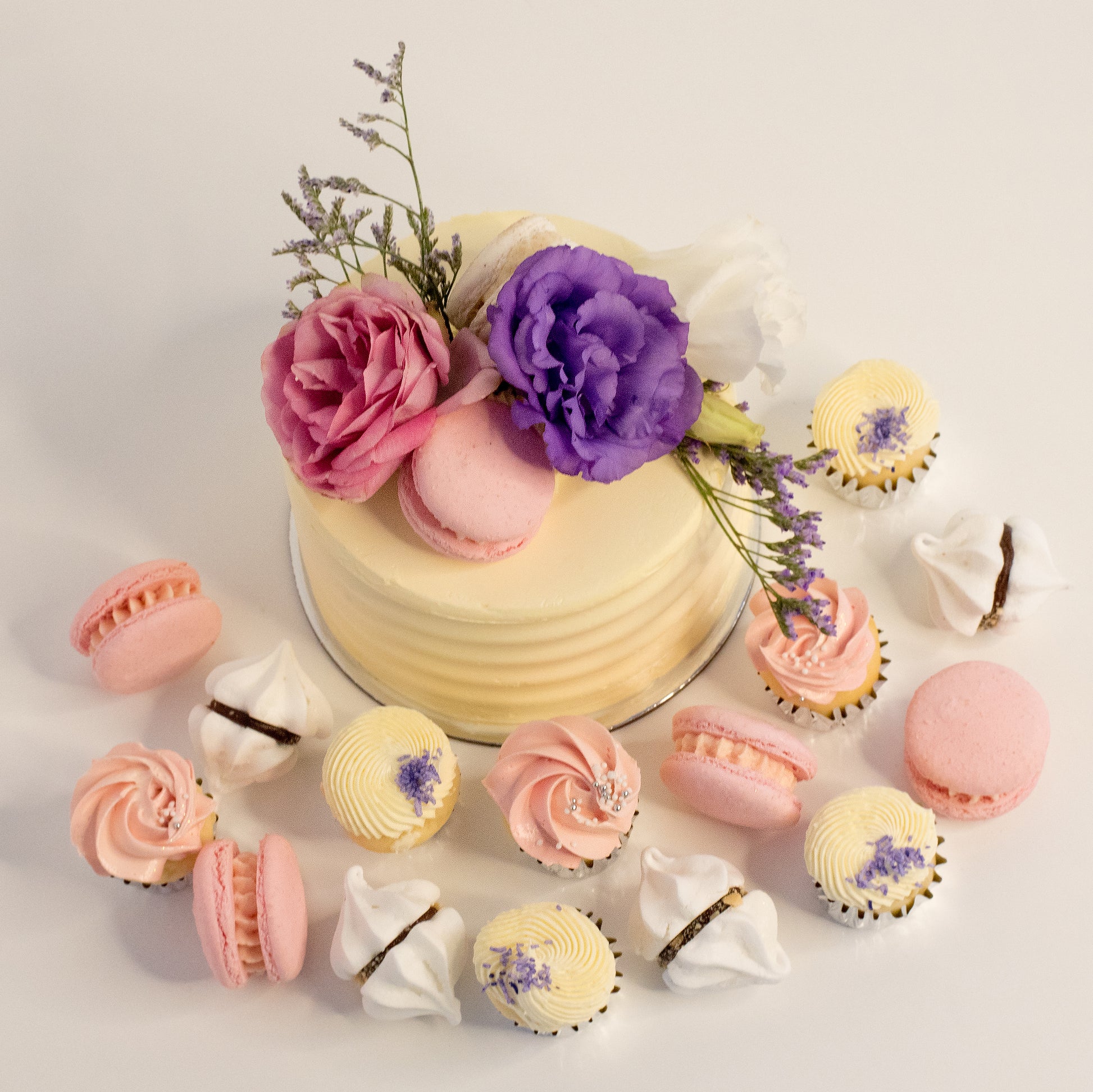 Cute cake and cupcake pack. This cake has a stunning arrangement of fresh flowers and macarons sweeping across the top. Plus mini cupcakes, meringue kisses and macarons. Ideal for work and corporate birthday celebrations. Cute Cakes & Co, Cute Cakes and Co, Brisbane online cake shop, Caxton Street cake shop