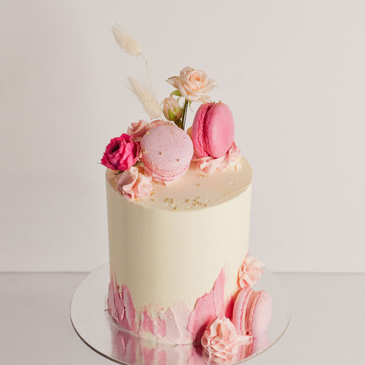 Pink birthday cake with fresh flowers, pussycat tails and macarons