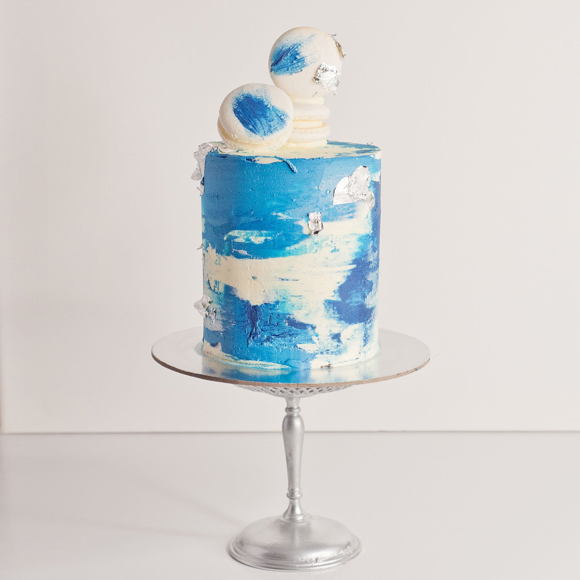 Maddox blue watercolour cake with silver leaf, white macarons and edible glitter